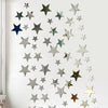 A collection of silver and green star-shaped acrylic mirror wall decor pieces arranged in a diagonal pattern.