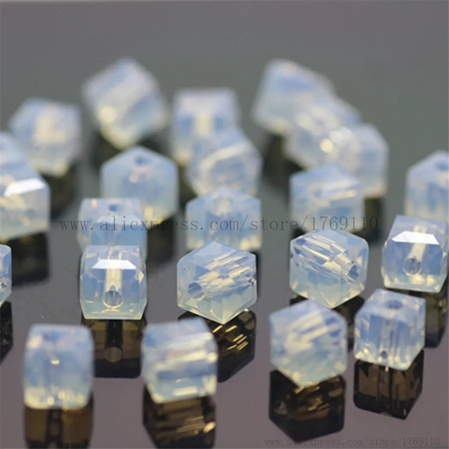 Square cut clear glass crystal beads used for jewelry making displayed on a dark surface