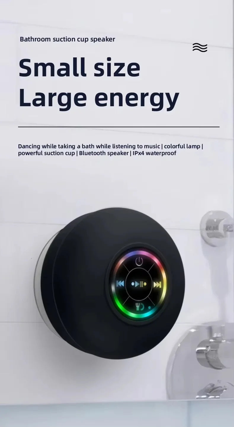 A black bathroom suction cup speaker is mounted on a white tile wall.