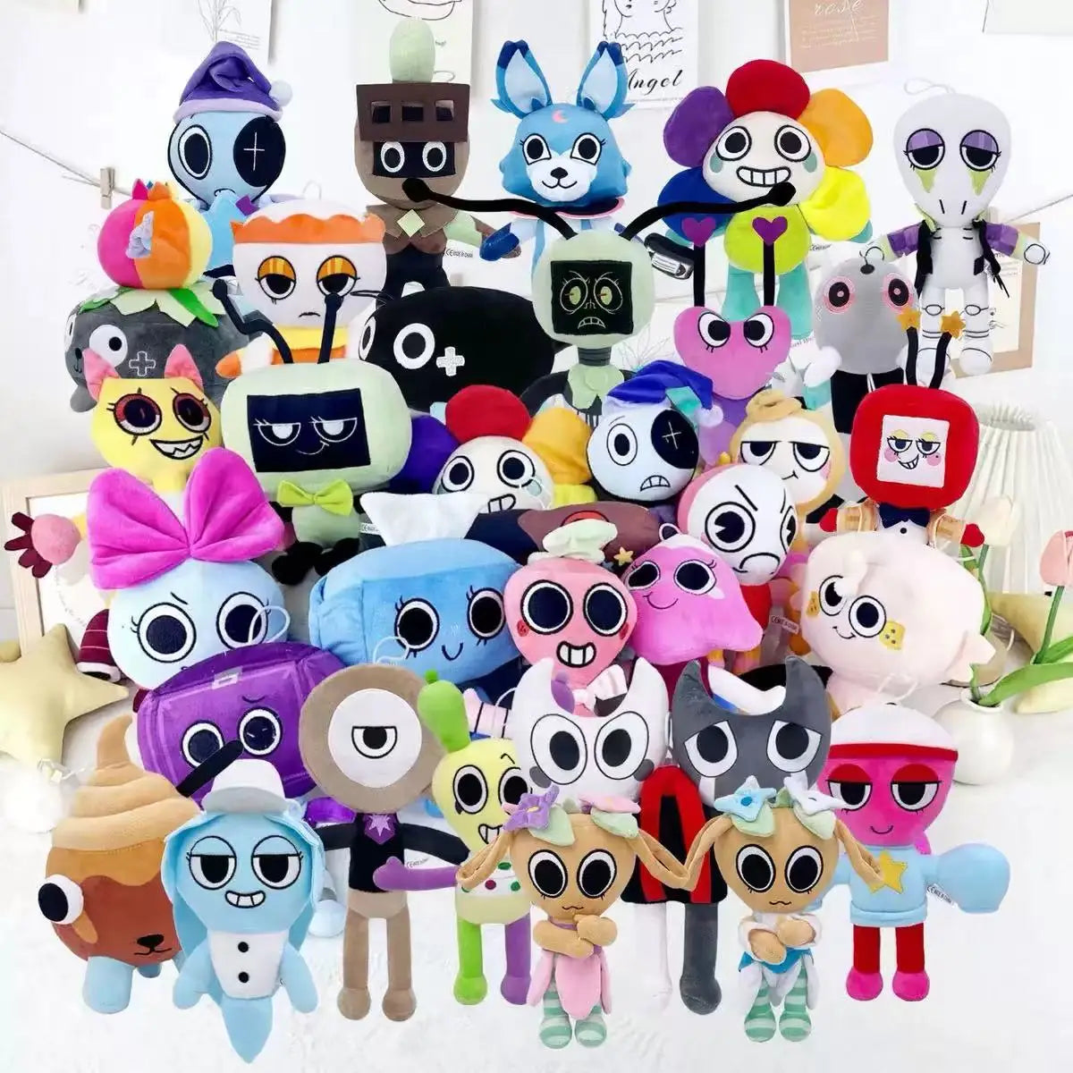 A collection of colorful Goob Boxten plush toys and stuffed animals arranged on a white surface.