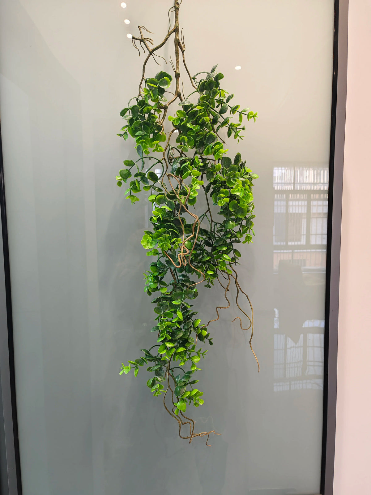 Artificial hanging ivy vine with green leaves displayed against a light background.