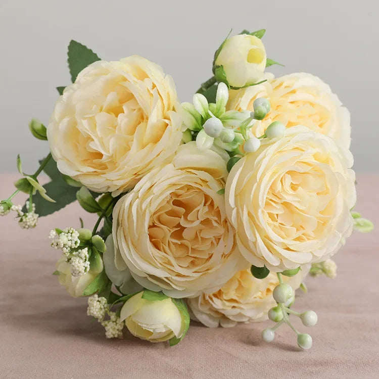 A bouquet of pale yellow silk rose and peony artificial flowers arranged for home or event decor.