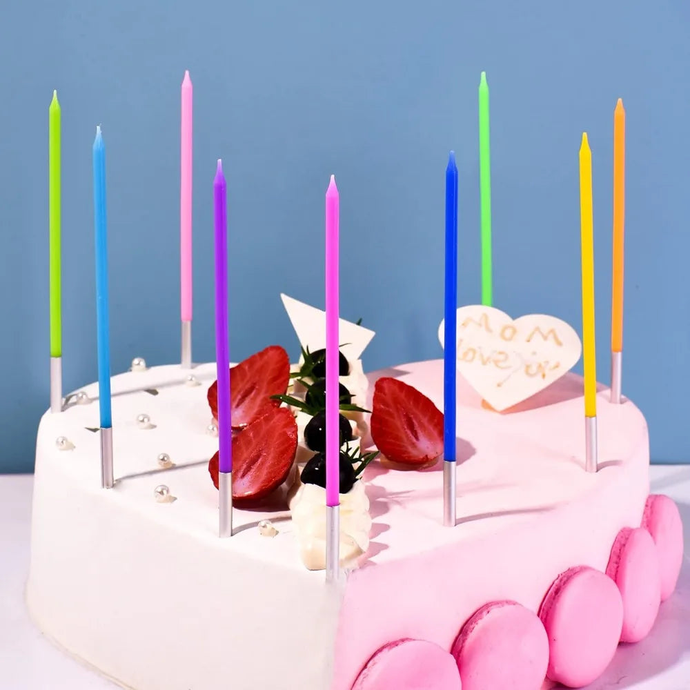 A pink birthday cake decorated with colorful thin candles and fresh strawberries.