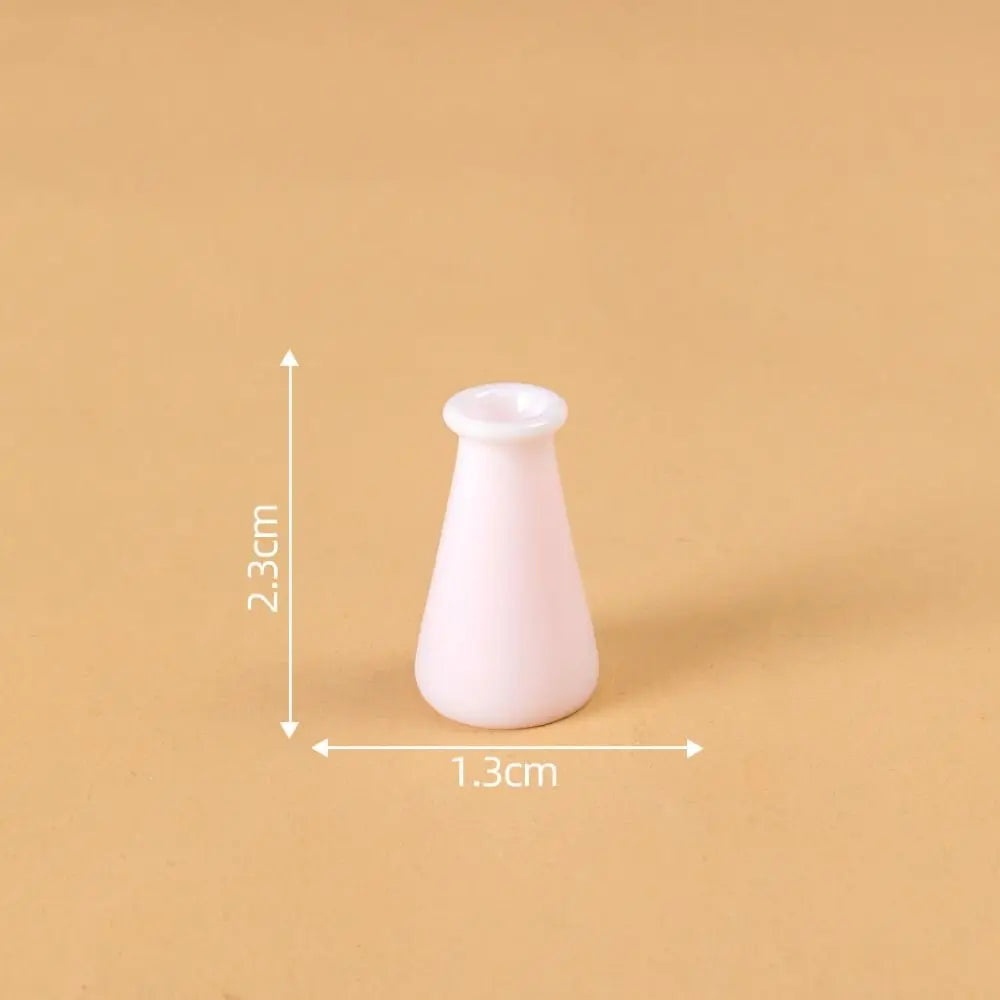 A small, white, tapered resin vase used for dollhouse decor, shown against a neutral background.