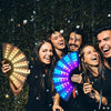 Five young adults smiling while holding a glowing LED fan for parties and events