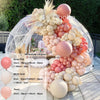 A kit of pink and beige balloons arranged in an arch or garland display.