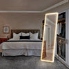Espejo LED de cuerpo completo con marco de aluminio, ubicado en un dormitorio.