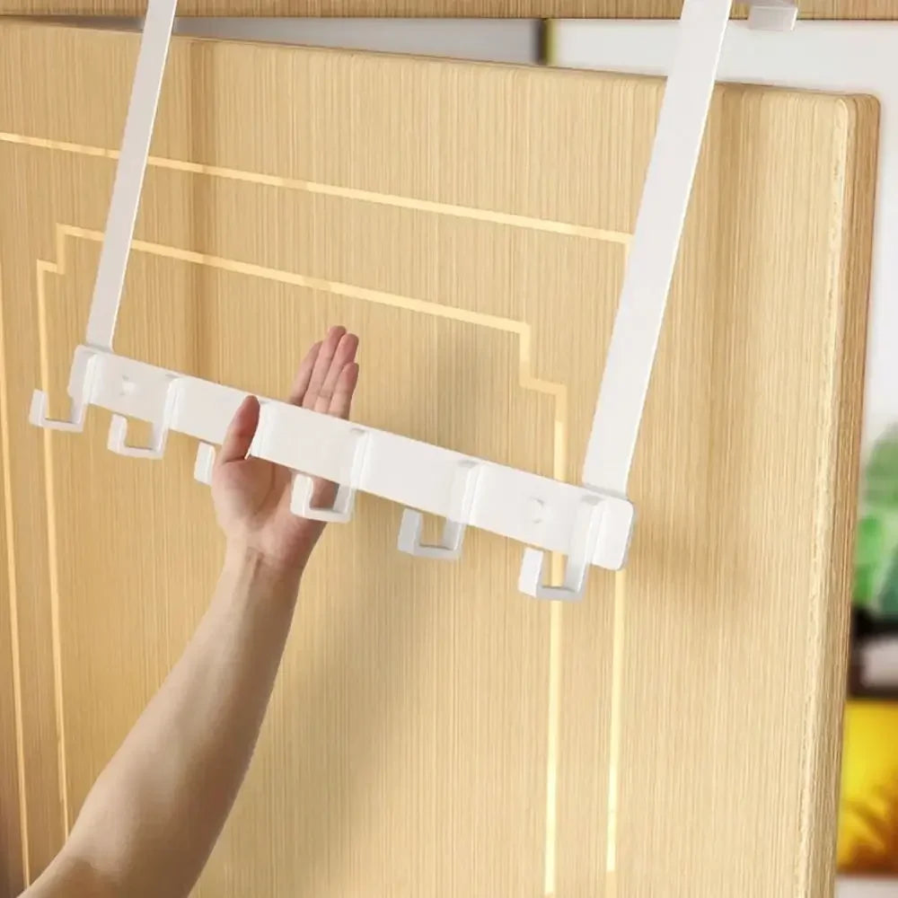 A hand is installing heavy duty aluminum door hooks onto a light wood cabinet door.
