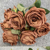 A collection of silk roses in various shades of orange, brown, and deep red, arranged as a bouquet.