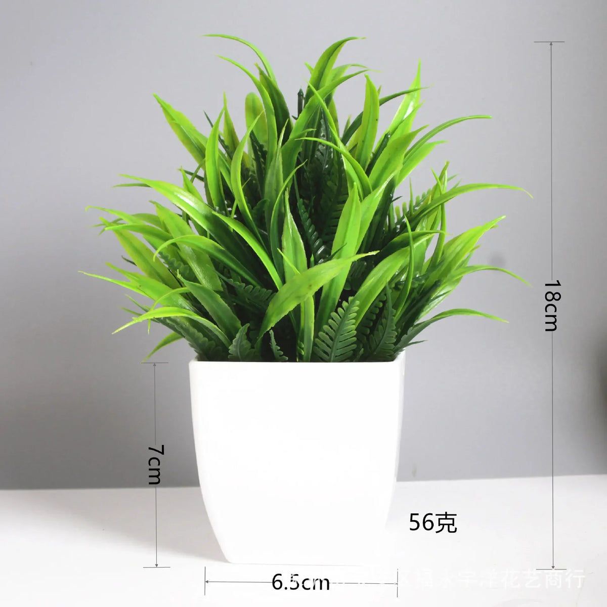 A potted artificial bonsai plant with green leaves and eucalyptus accents in a white pot.