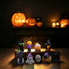 A collection of spooky resin figurines, including jack-o'-lanterns and witches, displayed on a wooden surface.
