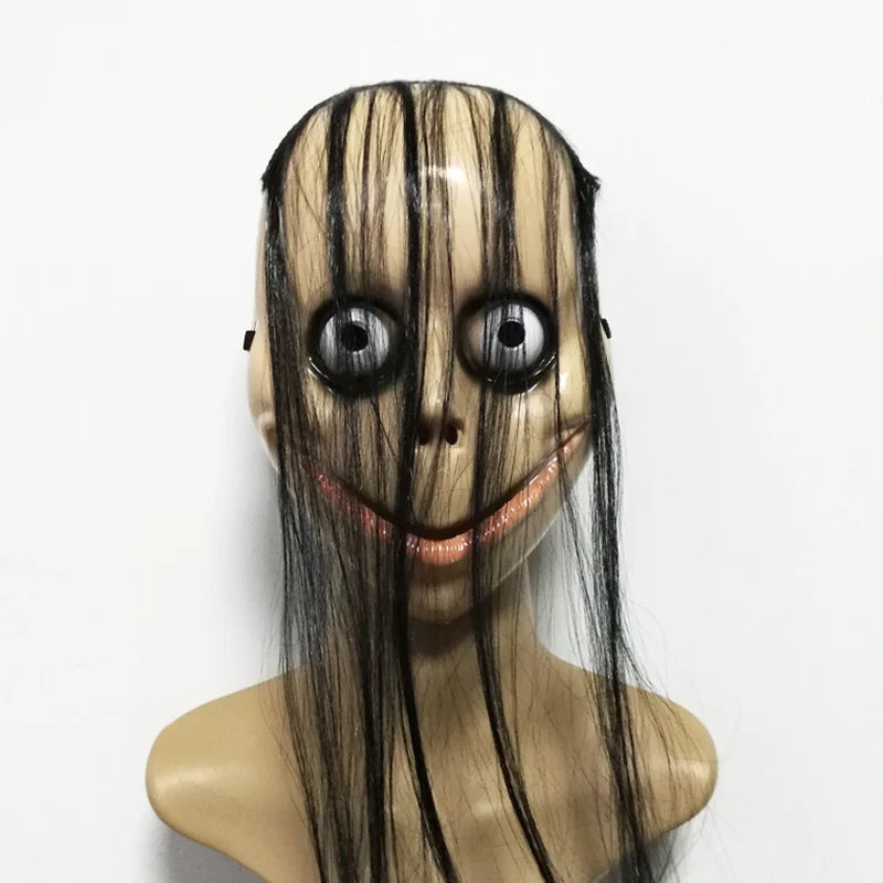 A realistic horror mask with pale skin, black hair, and large dark eyes smiling.