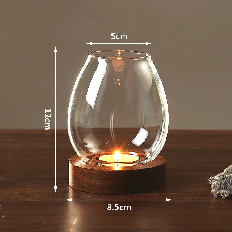 A vintage wooden candle lantern with a glass cover is lit on a dark wooden surface.