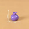 A small, round purple resin vase with a narrow neck is shown against a plain brown background.