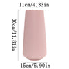 A tall, ribbed pink ceramic flower vase with a cylindrical shape.