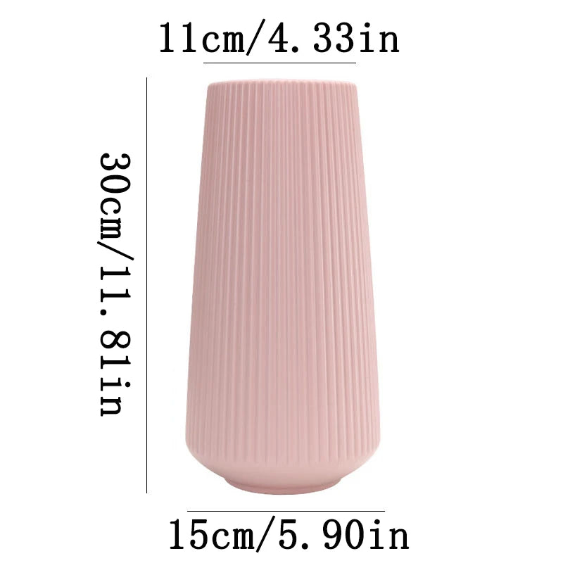 A tall, ribbed pink ceramic flower vase with a cylindrical shape.