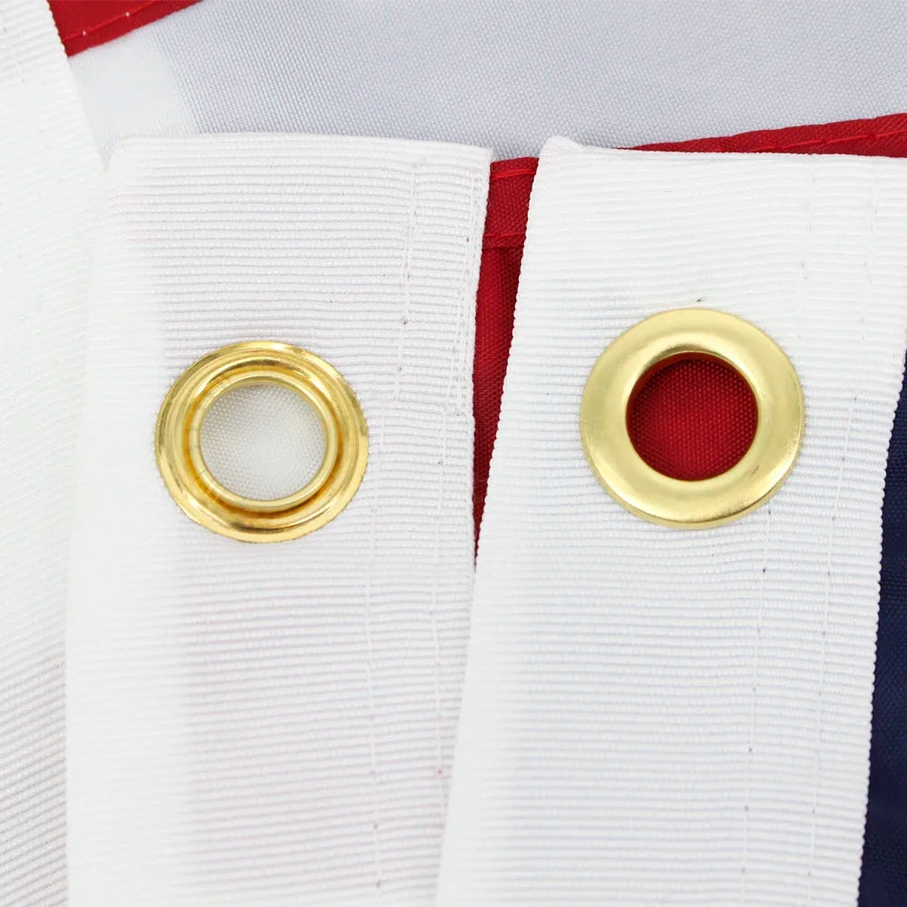 Close-up of a white flag banner with gold grommets against a red and blue background.