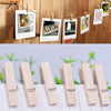 A row of natural wooden mini clothespins for crafts and decor displayed on a white surface.