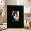 A black linen photo album displaying a portrait of a bride and groom.