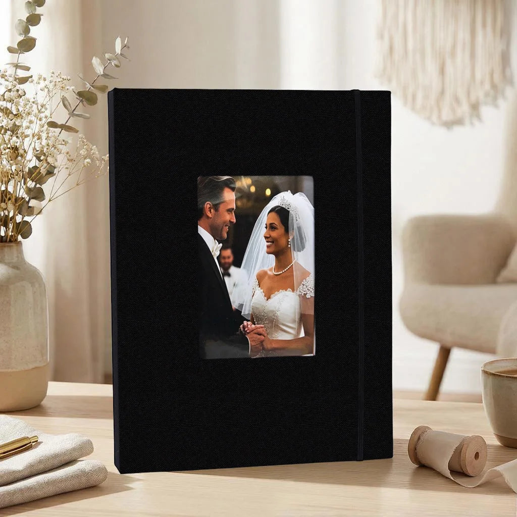 A black linen photo album displaying a portrait of a bride and groom.