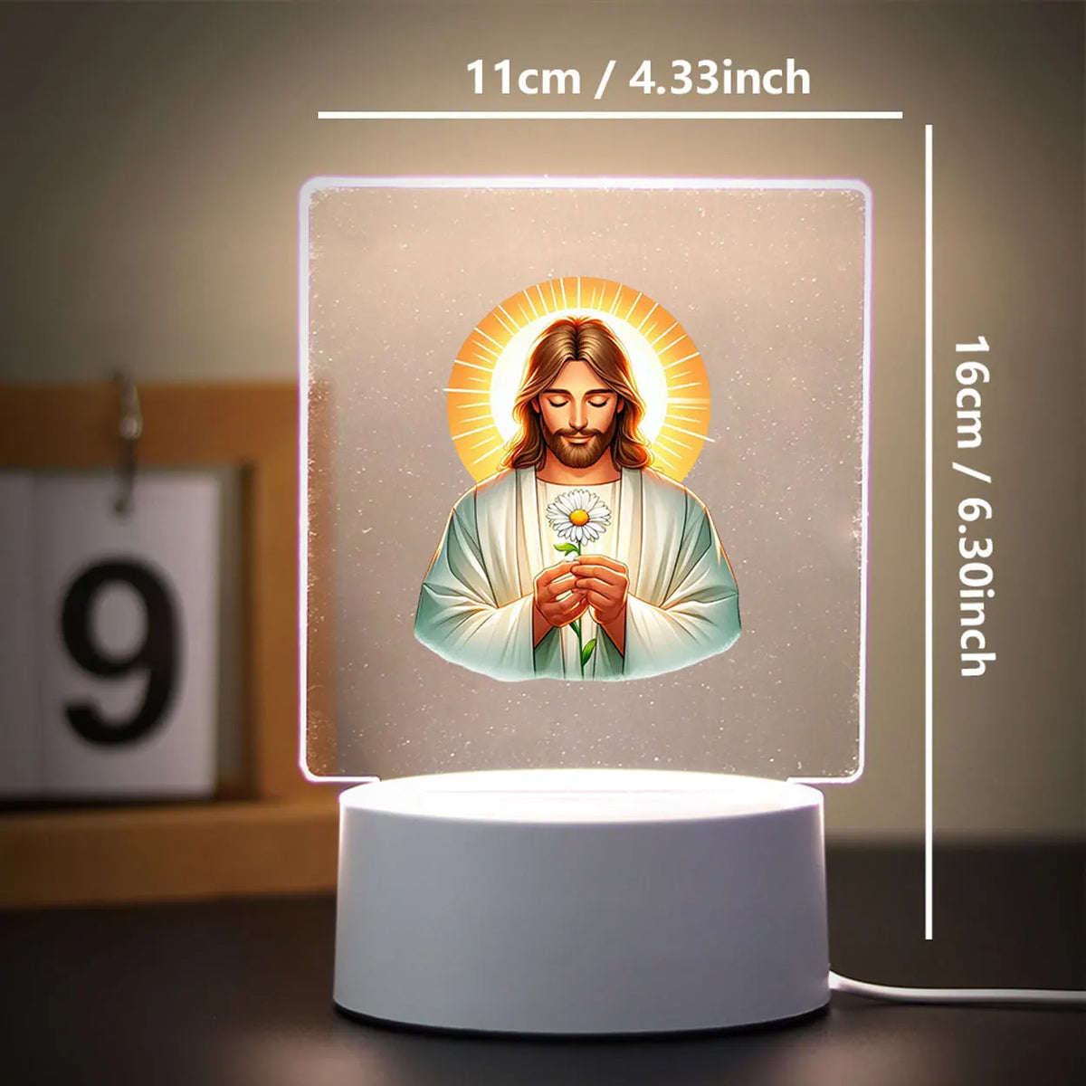 A glowing 3D LED night light featuring a depiction of Jesus with a halo on a square base.
