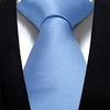 A light blue silk necktie tied in a knot against a black suit jacket.