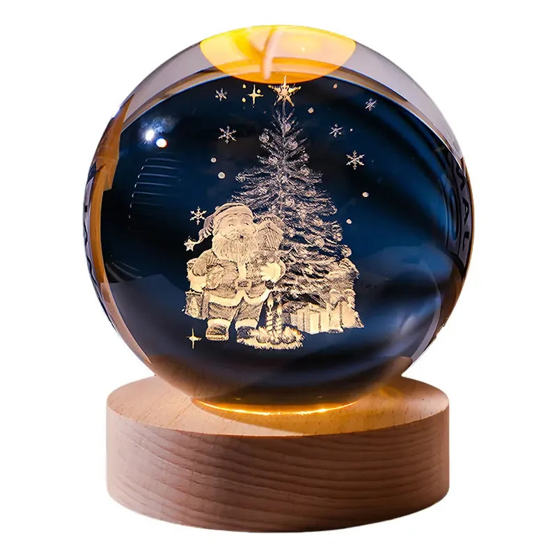 A dark blue crystal ball decoration featuring a laser engraved silhouette of a person standing next to a Christmas tree.