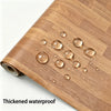 A wooden cutting board with water droplets on its surface.