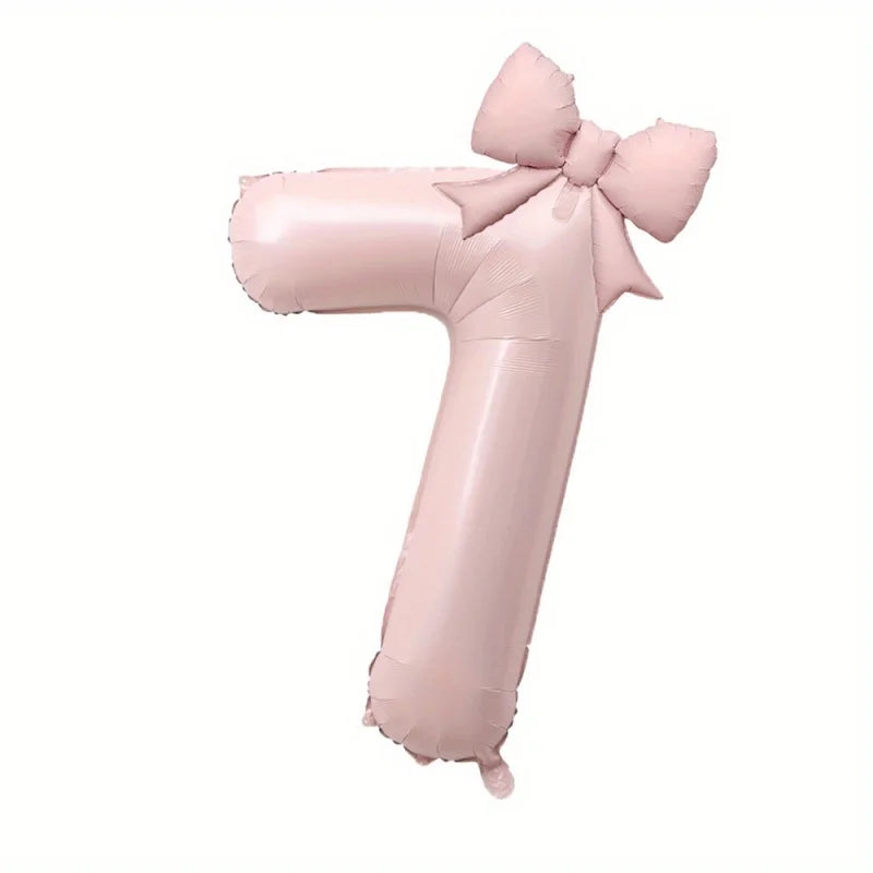 A large pink foil number balloon shaped like the number one with a bow.