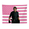 Ein Mann in Schwarz steht vor einem Wandteppich mit rosa-weiß gestreifter US-Flagge.