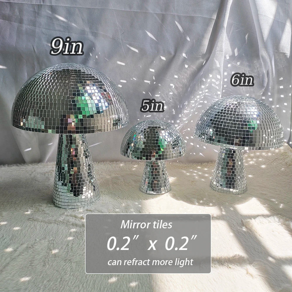 Three mushroom-shaped mirror tiles with silver iridescent facets displayed on a white surface.