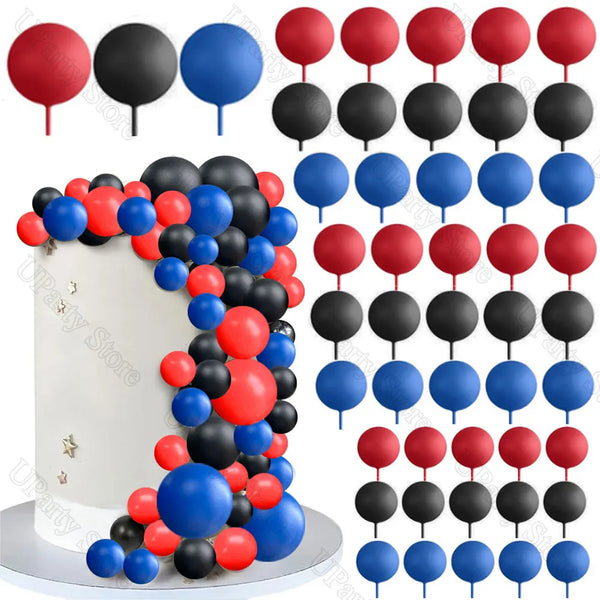 A set of colorful foam cake balls in red, black, and blue are arranged on a white cake stand.