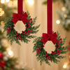 A set of two festive Christmas wreaths with green foliage and red berries, tied with red ribbon, hanging against a soft backg