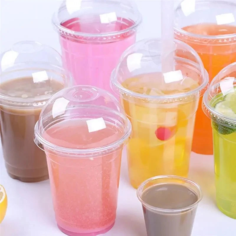 A collection of colorful fruit juices and smoothies in clear disposable plastic cups with lids.