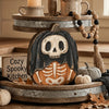 A vintage Halloween pumpkin decor set featuring a carved skull pumpkin and decorative gourds on a wooden tray.