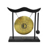 A black desktop zen gong with a wooden mallet mounted on a stand.