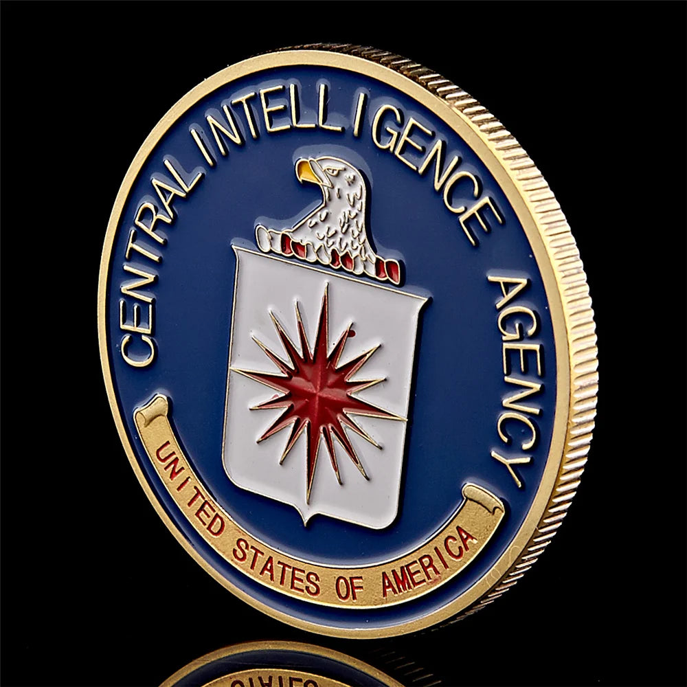 Gold-plated CIA challenge coin featuring an eagle and stars, set in a protective case.