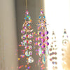 A pair of dangling celestial sun and moon crystal suncatchers featuring iridescent glass beads.