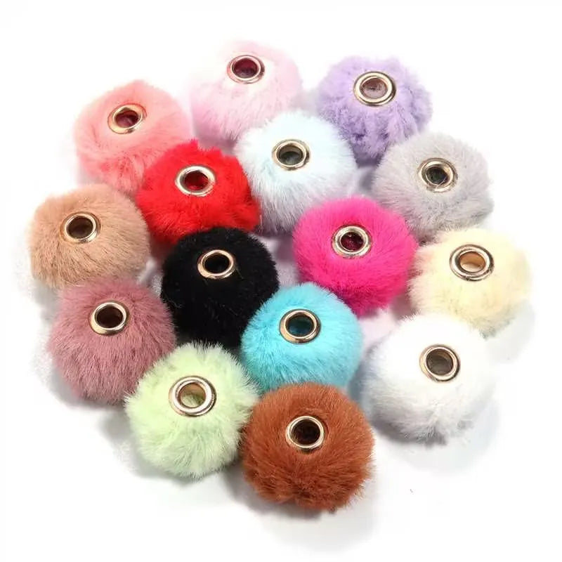 Collection de perles en peluche colorées, dans des tons de rose, violet, rouge et beige.