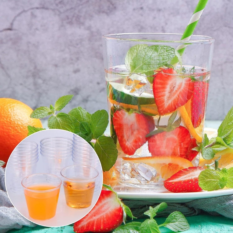 A glass filled with sliced strawberries, citrus, and mint leaves, set against a blurred background.