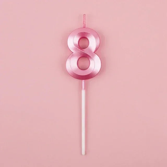 A pink number eight candle with a white stick against a light pink background.