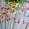 A close-up of a crystal rainbow maker sun catcher with love circle pentacle design featuring iridescent and clear crystals.