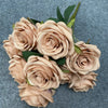 A bouquet of nine soft peach colored silk roses with green leaves for weddings and home decor