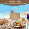 A natural jute tote bag filled with various items, set on a wooden table outdoors near the sea.