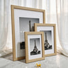 A set of three wooden photo frames displaying images of the Eiffel Tower.