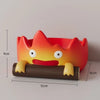 A resin key tray and desk organizer shaped like a cute, orange fire spirit with yellow accents.