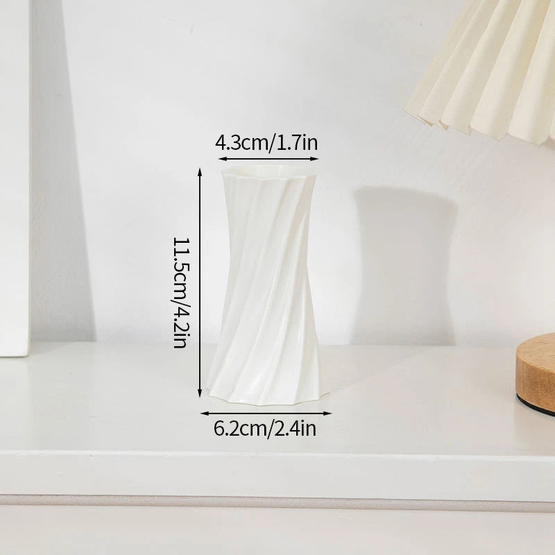 Weiße, plissierte moderne Plastikblumenvase auf weißer Oberfläche.
