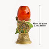 A golden chime with a tree of life pendant and an amber-colored crystal ball.