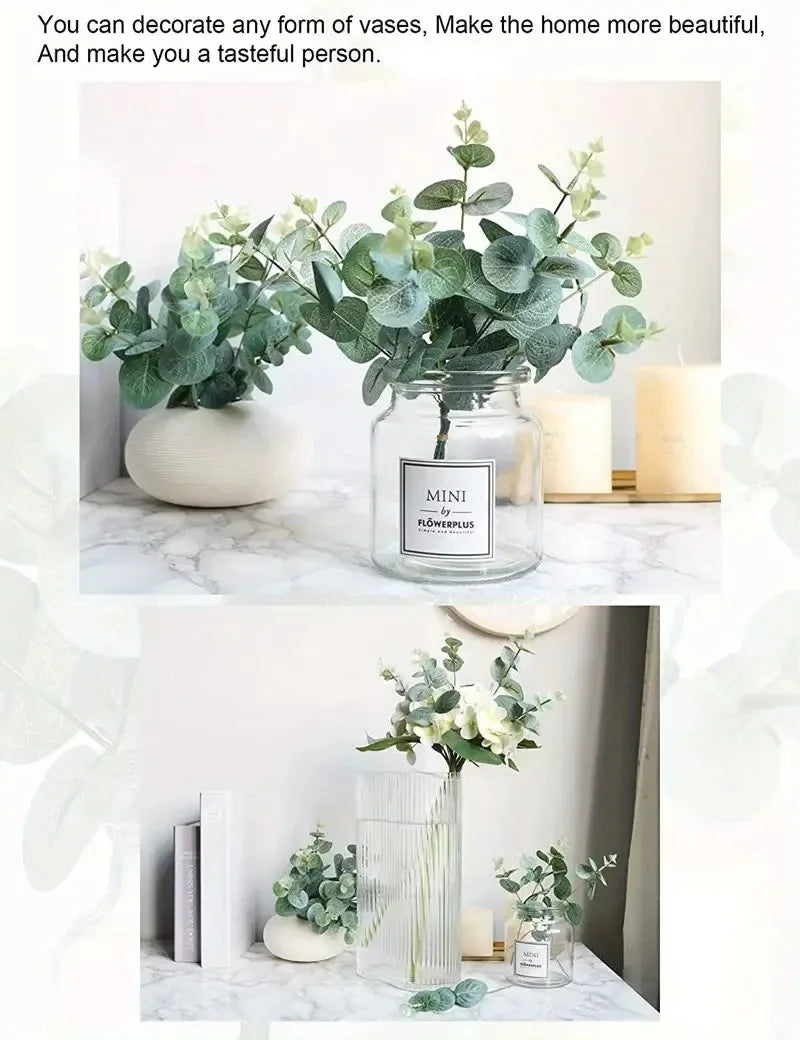A glass vase filled with green eucalyptus leaves displayed on a white marble surface.