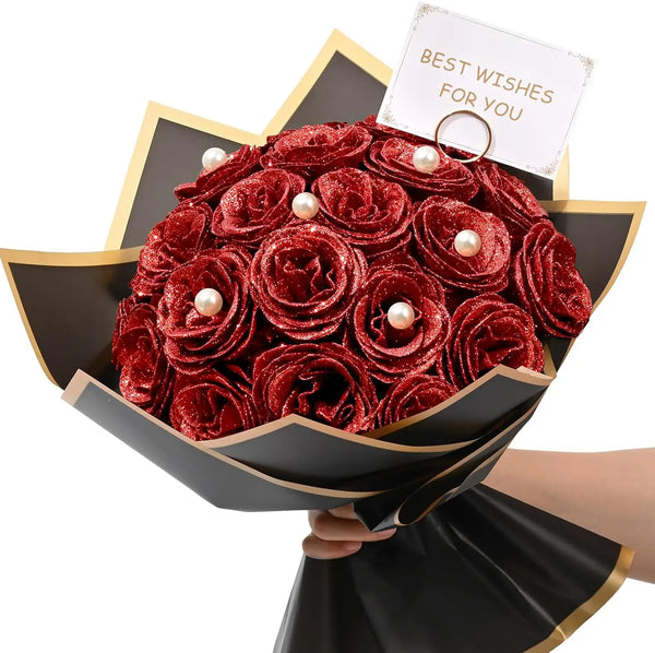 A bouquet of deep red glitter roses with white pearl accents presented in a black paper holder.